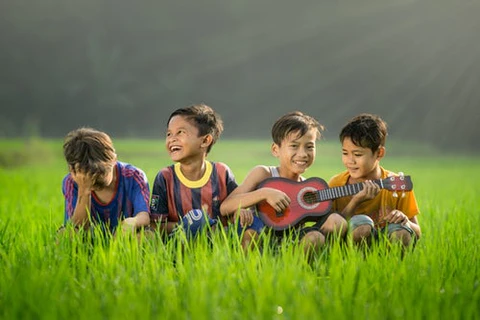 Fiús játékok négy kisfiú fűben gitárral focimezben