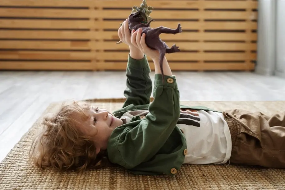 állatfigurákkal játszó kisfiú